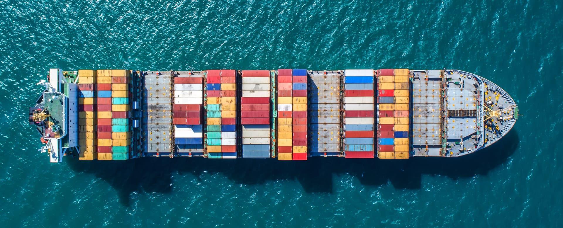 Aerial view of container ship transporting cargo containers at sea